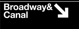 Street sign indicating 'Broadway & Canal' with an arrow pointing downwards on a black background.